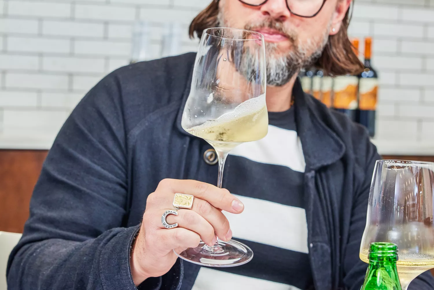 Person swirling white wine in Josephinenhütte Josephine No. 2 Universal Wine Glass while holding it by the stem