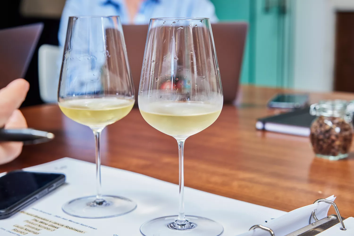 Two Richard Brendon x Jancis Robinson The Perfect Wine Glass glasses filled with white wine set on sheet of paper
