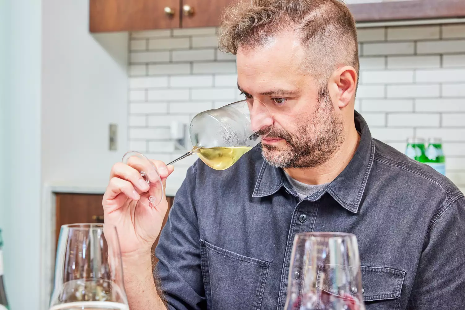 Person sniffing white wine in Josephinenhüttee Josephine No. 2 Universal wine glass while holding it by the stem