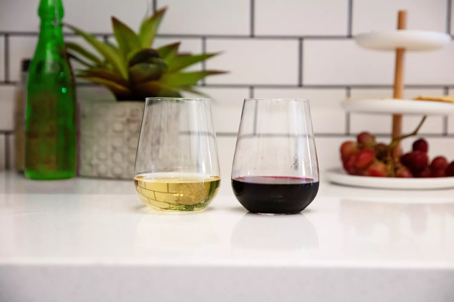 Two Glasvin The Stemless wine glasses on a white kitchen counter