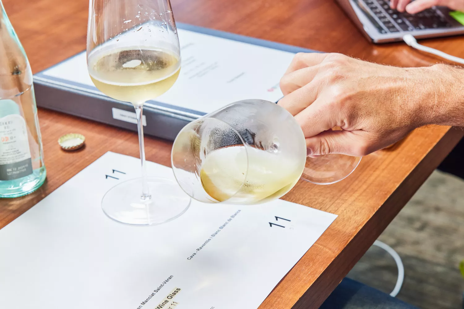 Hand tilting white wine in a glass from Glasvin Universal Wine Glasses, Set of 2